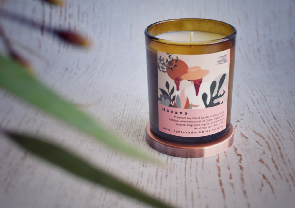 Amber jar candle with colourful label with a leafy branch decoration 