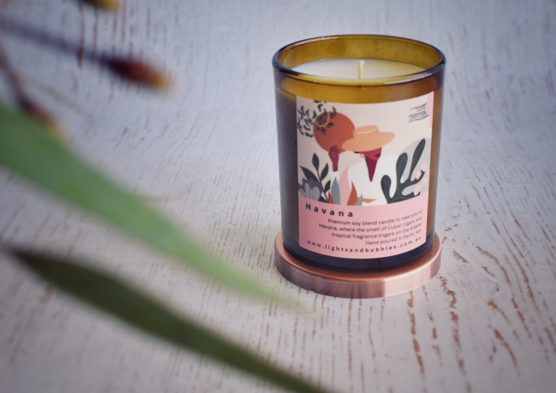 Amber jar candle with colourful label with a leafy branch decoration 