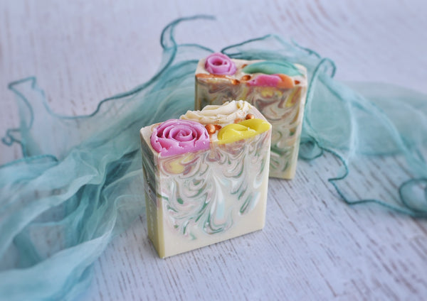 white base soap with drop swirl in green, yellow, orange with soap flower decoration 