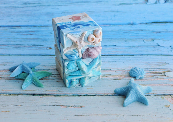 Landscape soap showing the sand and the sea with a starfish in the soap with sea themed soap top