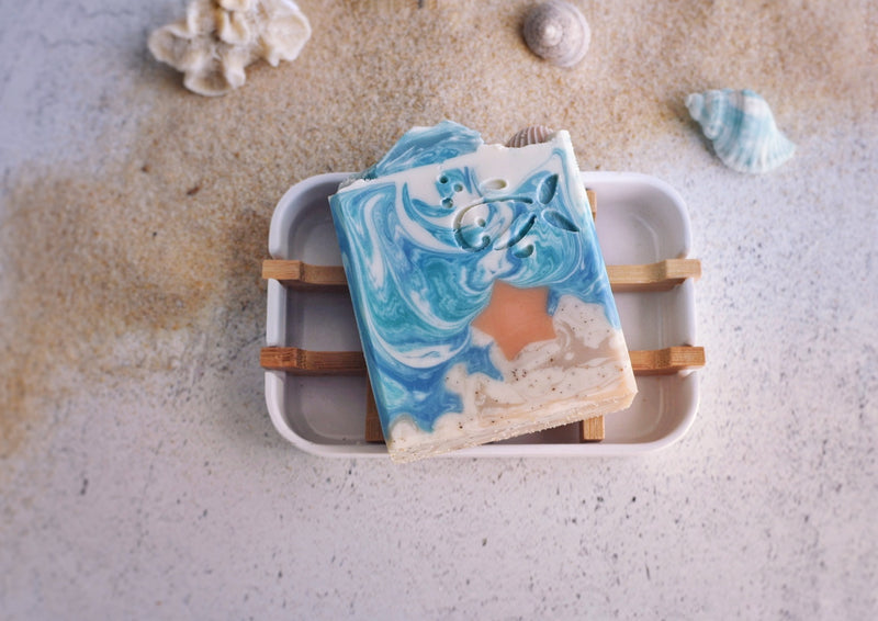 Landscape soap showing the sand and the sea with a starfish in the soap with sea themed soap top on a bamboo soap dish 